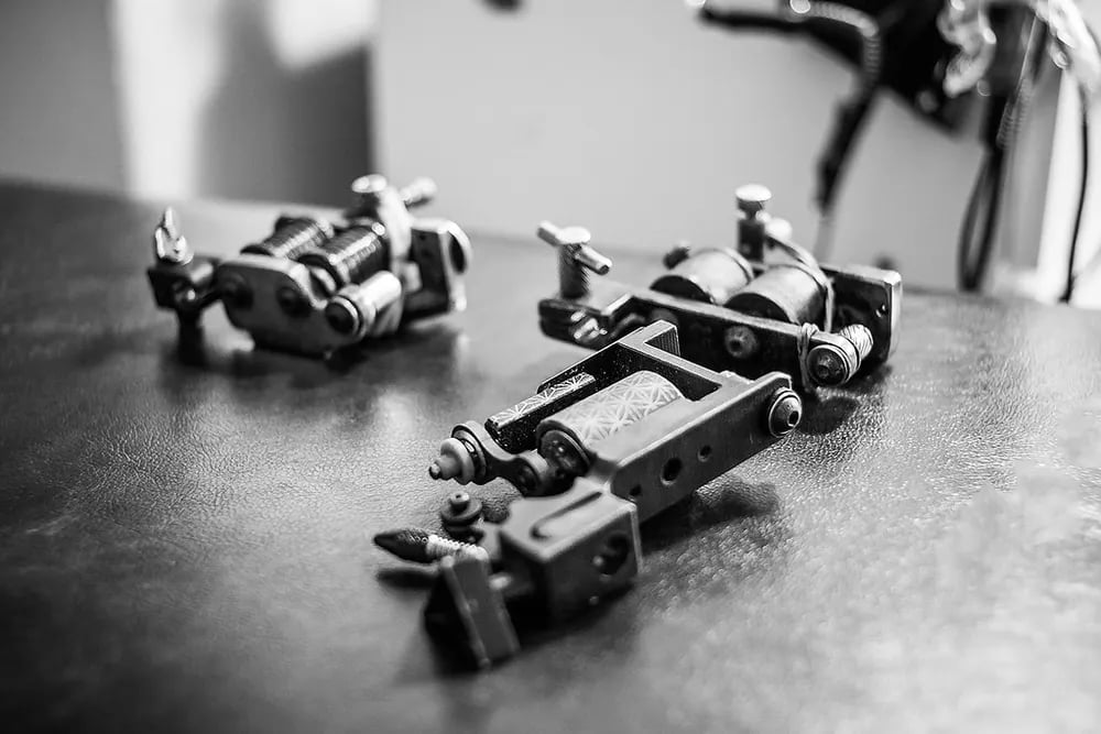 Row of tattoo machines on a workbench