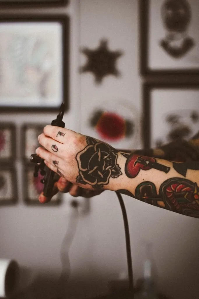 Hand covered in traditional roses in front of a flash wall