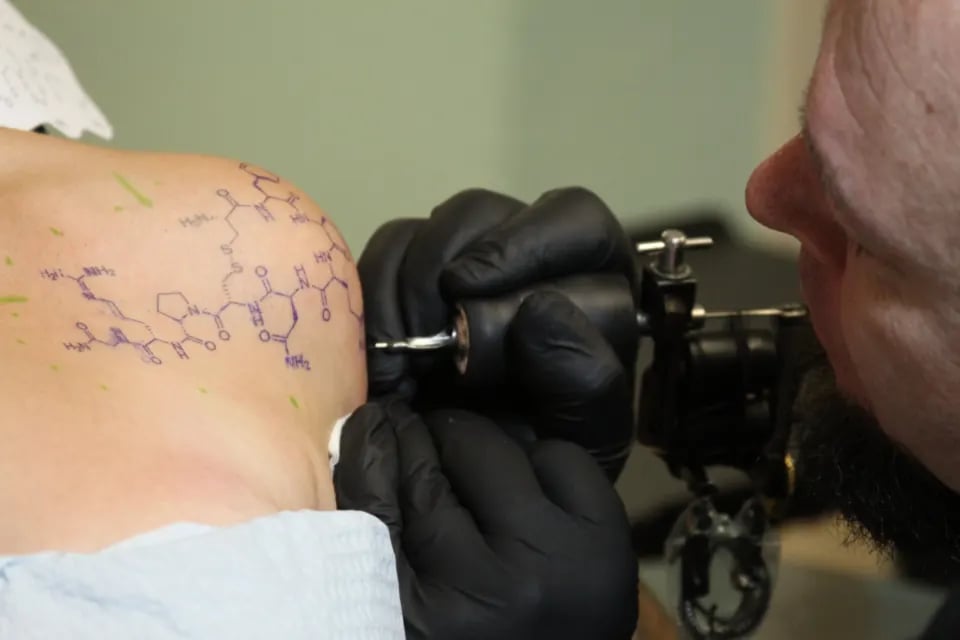 Artist placing a stencil on a client's arm